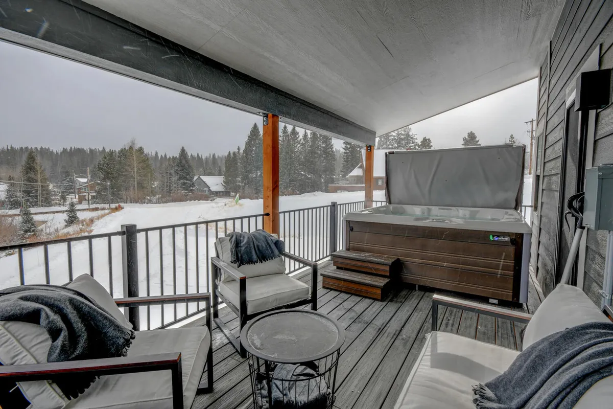 An outdoor hot tub surrounded by a snowy landscape, with inviting seating and a backdrop of winter scenery. The scene emphasizes relaxation and enjoyment of exclusive amenities in a tranquil, high-end alpine setting.